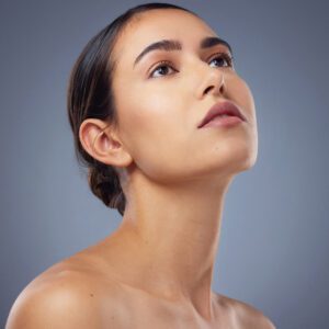 Studio shot of a beautiful young woman posing against a grey background.
