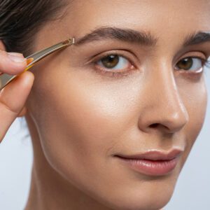 Charming young female keeping smile on her face while posing on camera