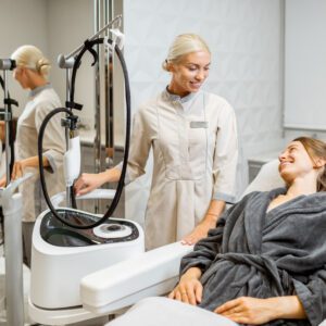Young woman client with a doctor during a facial rejuvenation treatment at medical SPA office. Concept of laser skin rejuvenation