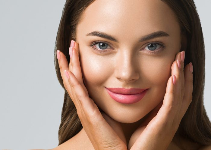 Beauty woman skin care beautiful female hand touching face cosmetic girl model over blue background